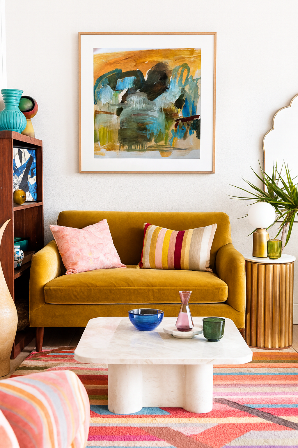 Living room with mustard yellow sofa, colorful rug, and abstract art on the wall.