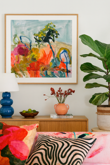 Decorative room interior with a colorful abstract painting, potted plant, and floral arrangement.