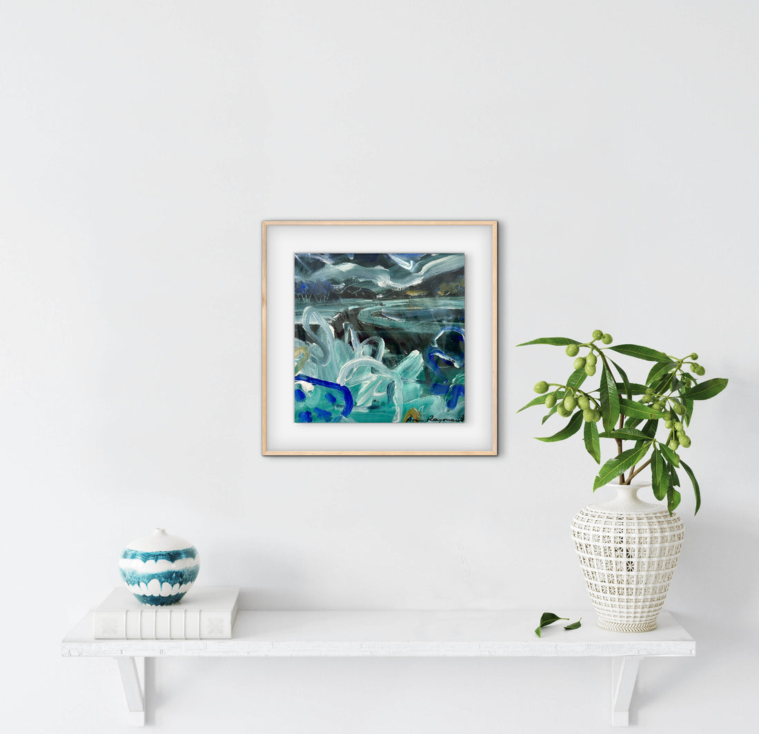 Framed abstract artwork on a white wall with decorative items below.